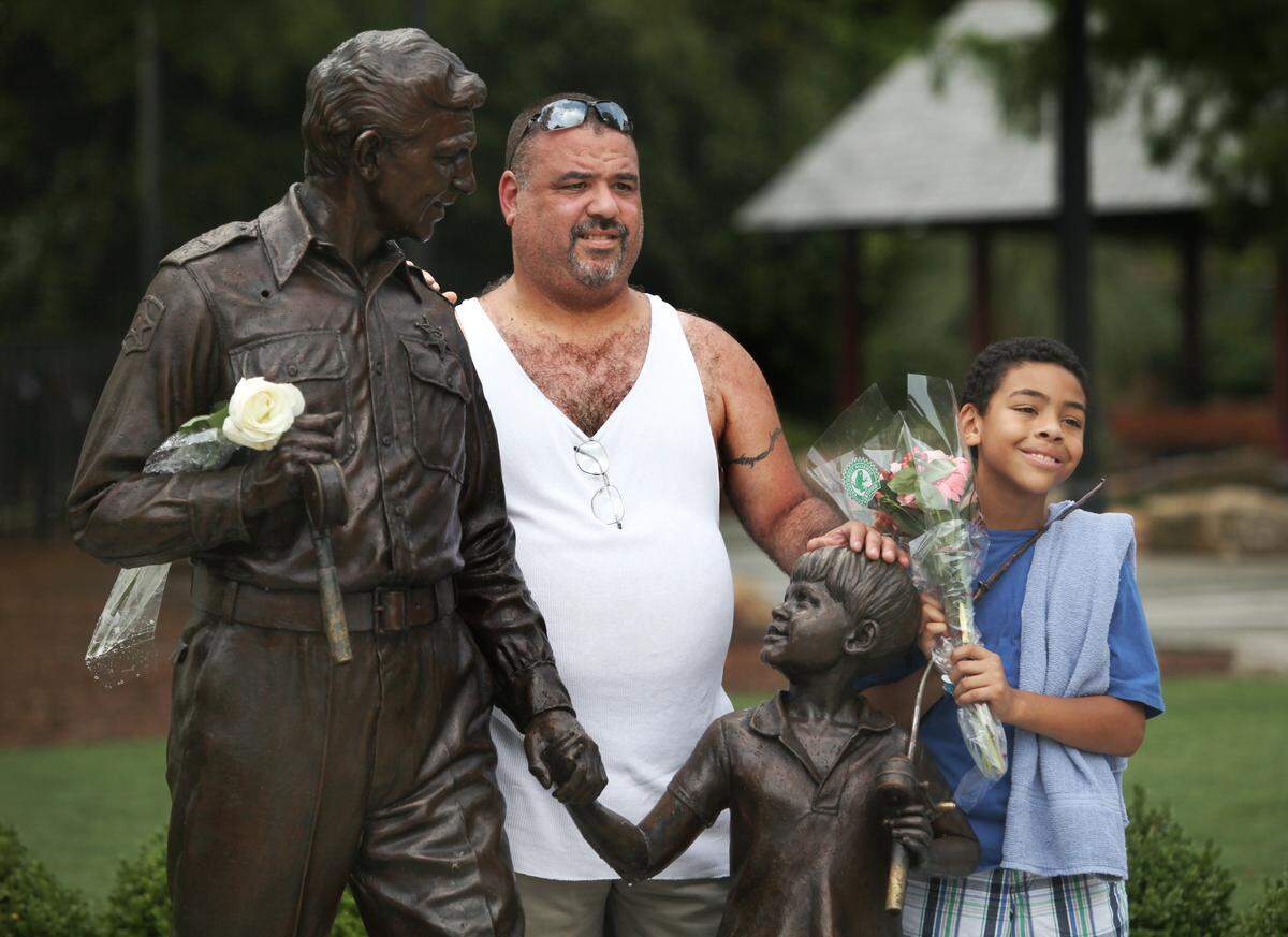 Michael Flack Sr. (left) and Michael Flack Jr. stand beside the statue of Andy Griffith and Ron Howard as their characters, Andy and Opie Taylor, from Griffith's television show on Tuesday, July 3, 2012 at Pullen Park in Raleigh, N.C.