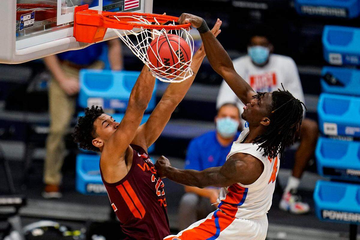 Florida forward Anthony Duruji (4) gets a dunk over Virginia Tech forward Keve Aluma (22) in overtime of a first round game in the NCAA men’s college basketball tournament at Hinkle Fieldhouse in Indianapolis, Friday, March 19, 2021. Florida defeated Virginia Tech Hokies 75-70. (AP Photo/Michael Conroy)