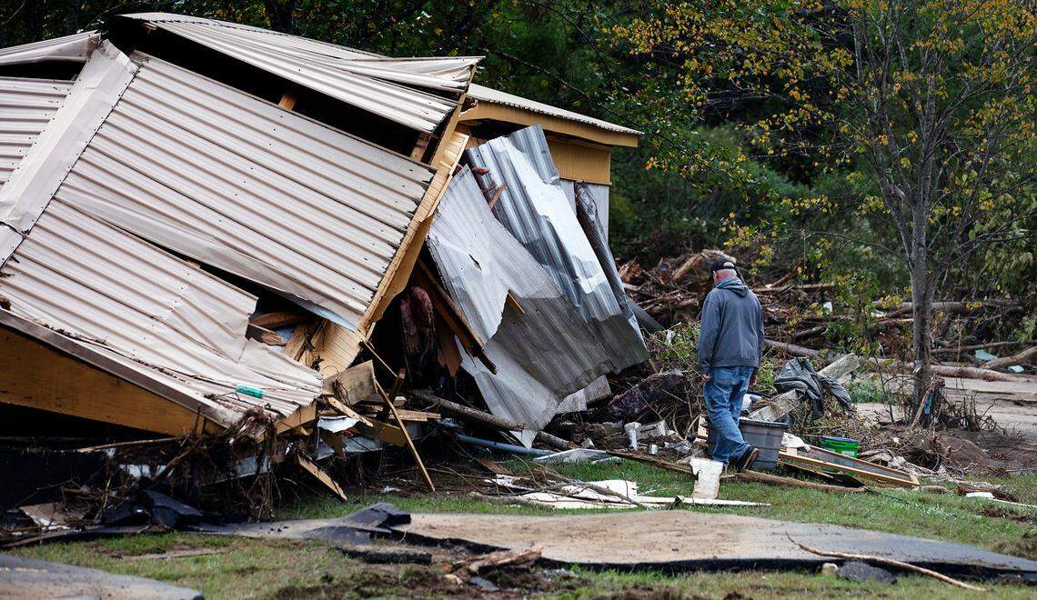 A person walks next to a demolished building in Frank, N.C. on Tuesday, Oct. 1, 2024, days after Hurricane Helene brought heavy rain and flooding to the western part of the state.