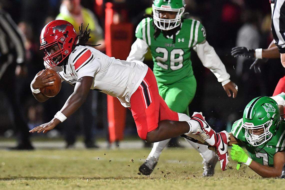 Middle Creek running back Jayden Spencer (0) gets the first down against the tackle from Cary's Jaylin Spivey (7) during the first half. The Cary Imps and the Middle Creek Mustangs met in a conference football game in Cary, N.C. on October 24, 2025