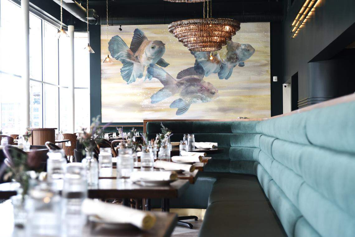 The giant windows at Delancey Tavern lend the dining room a fishbowl effect. So the owners put some koi fish on the wall.