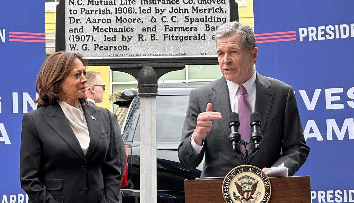 Gov. Roy Cooper speaks with Vice President Kamala Harris looking on during Vice President Harris’ trip to Durham’s historic Black Wall Street district on Friday March 1, 2024.