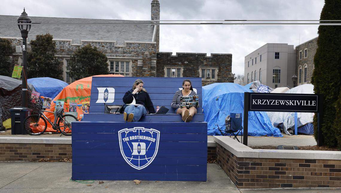 Duke seniors Lily Baglio, left, and Kaitlyn Williams work on an oversized bench in Krzyzewskiville at Duke University in Durham, N.C., on Feb. 18, 2026. It is the 40th anniversary of the annual tent city for tickets for the Blue Devils’ game against North Carolina.