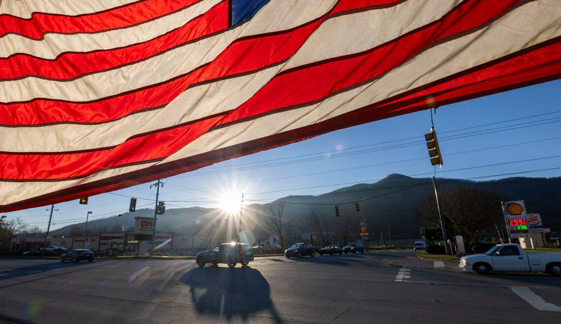 The sun rises over Swannanoa, North Carolina on Friday, December 20, 2024 illuminating a large American Flag that greets those entering the town on Patton Cove Road. Swannanoa was heavily damaged by Hurricane Helene which flooded the Swannanoa River causing catastrophic damage to the Buncombe County town.