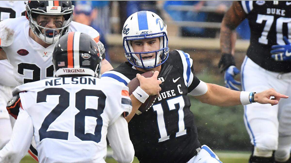 Duke quarterback Daniel Jones (17) looks for running room as Virginia safety Brenton Nelson (28) and defensive back Darrius Bratton (32) close in during the second quarter. 