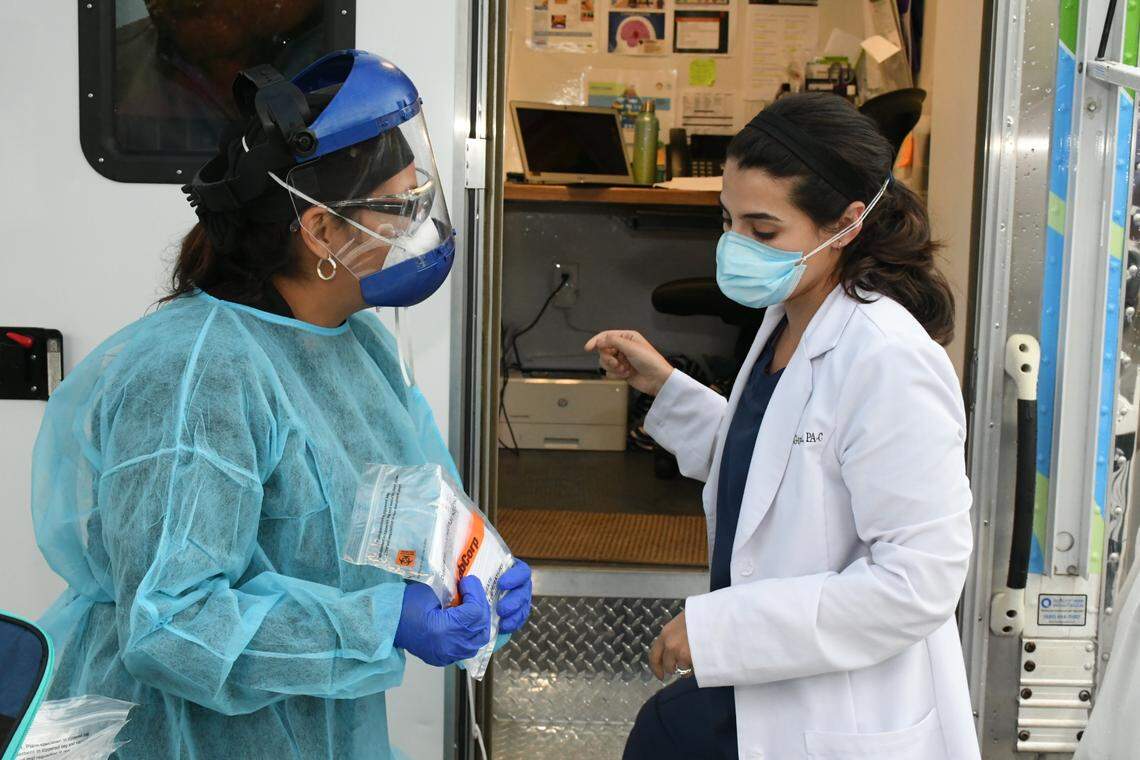 Marta Negrón, nurse at LliBot Consultorios Médicos talks to Mónica González, doctor at LliBot Consultorios Médicos about coronavirus tests for Latino patients at the parking lot of Villa Latina Plaza in Raleigh on June 16.