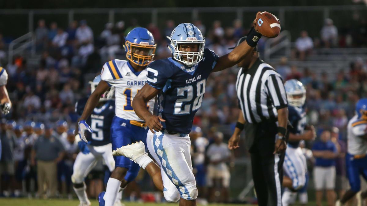 Cleveland running back Omarion Hampton (28) holds the ball up as he crosses the goal line for a first-quarter touchdown during the Garner Trojans’ football game at the Cleveland Rams on Friday, August 30, 2019.