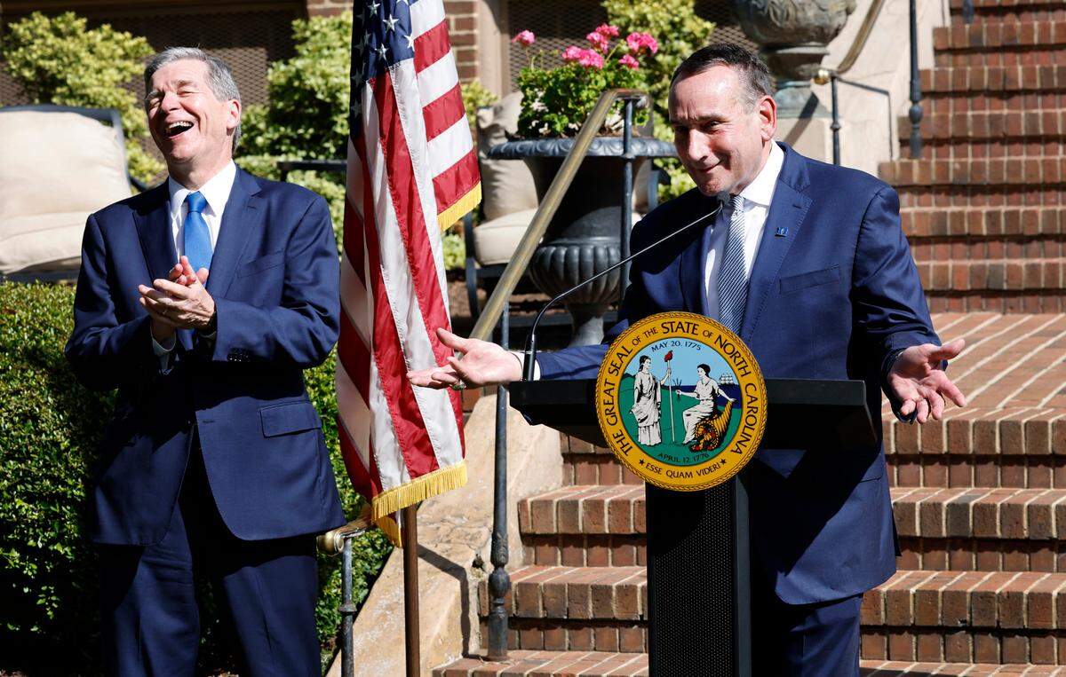 N.C. Gov. Roy Cooper laughs with former Duke men’s basketball head coach Mike Krzyzewski as he speaks after receiving The Order of the Long Leaf Pine award during a ceremony at the Executive Mansion in Raleigh, N.C., Thursday, Sept. 1, 2022. The Order of the Long Leaf Pine award is the state’s highest civlian honor.