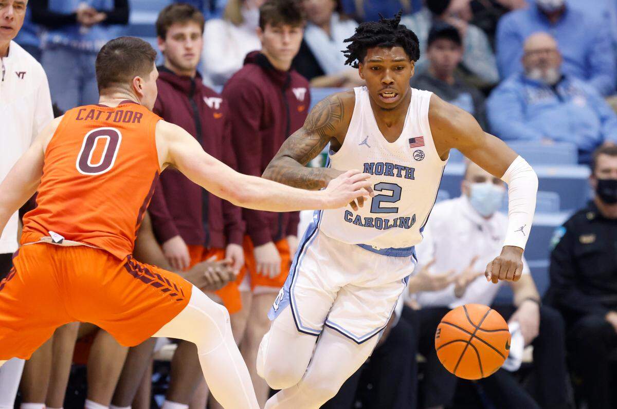 North Carolina’s Caleb Love (2) drives by Virginia Tech’s Hunter Cattoor (0) during the second half of UNC’s 78-68 victory over Virginia Tech at the Smith Center in Chapel Hill, N.C., Monday, Jan. 24, 2022.