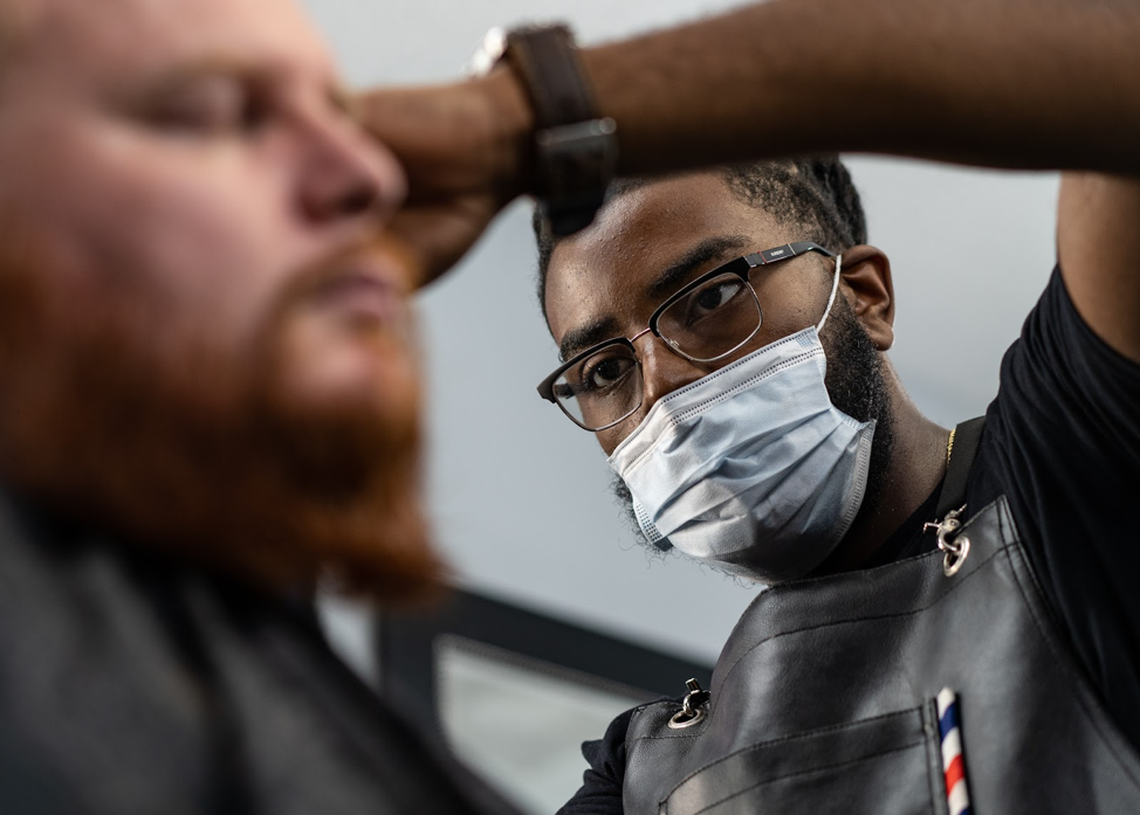 Will Cagle cuts a client’s hair at Gentlemen Quarters Barbershop in Durham, N.C.