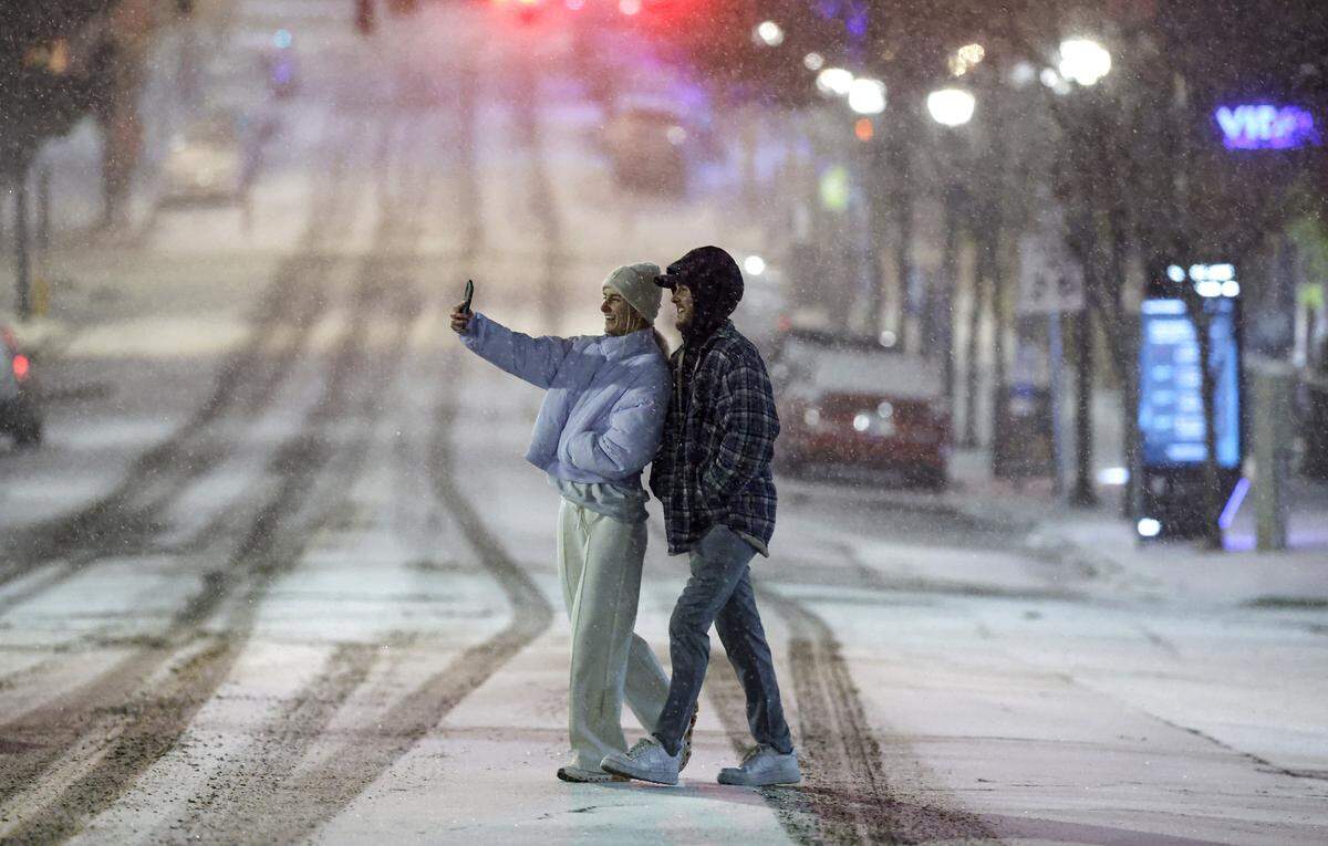 A couple take a selfie in Glenwood South in Raleigh, N.C., Saturday evening, Jan. 31, 2026.