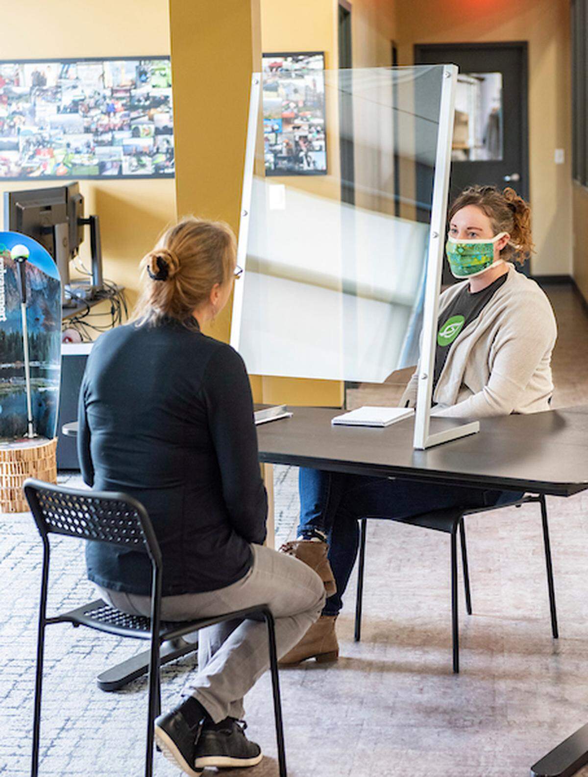 SylvanSport employees sit around one of their counter-top protective shields on 4/2/20.