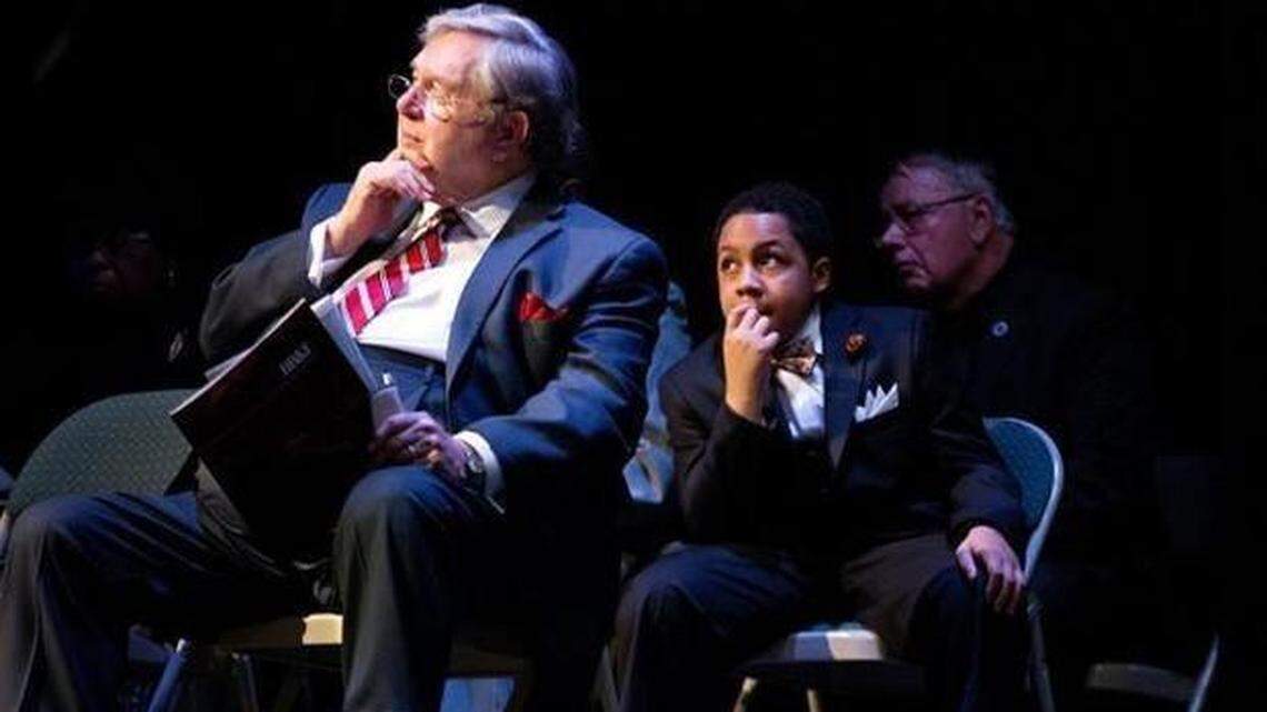 Dr. Vernon Tyson, left, Donovan Summers, 11, middle, and Garner Mayor Ronnie Williams listen to Dwight Rodgers recite “I Have a Dream” during the fifth annual Celebration of the Life and Legacy of the Rev. Dr. Martin Luther King Jr. at the Garner Performing Arts Center Jan. 18. Donovan also spoke during the event.