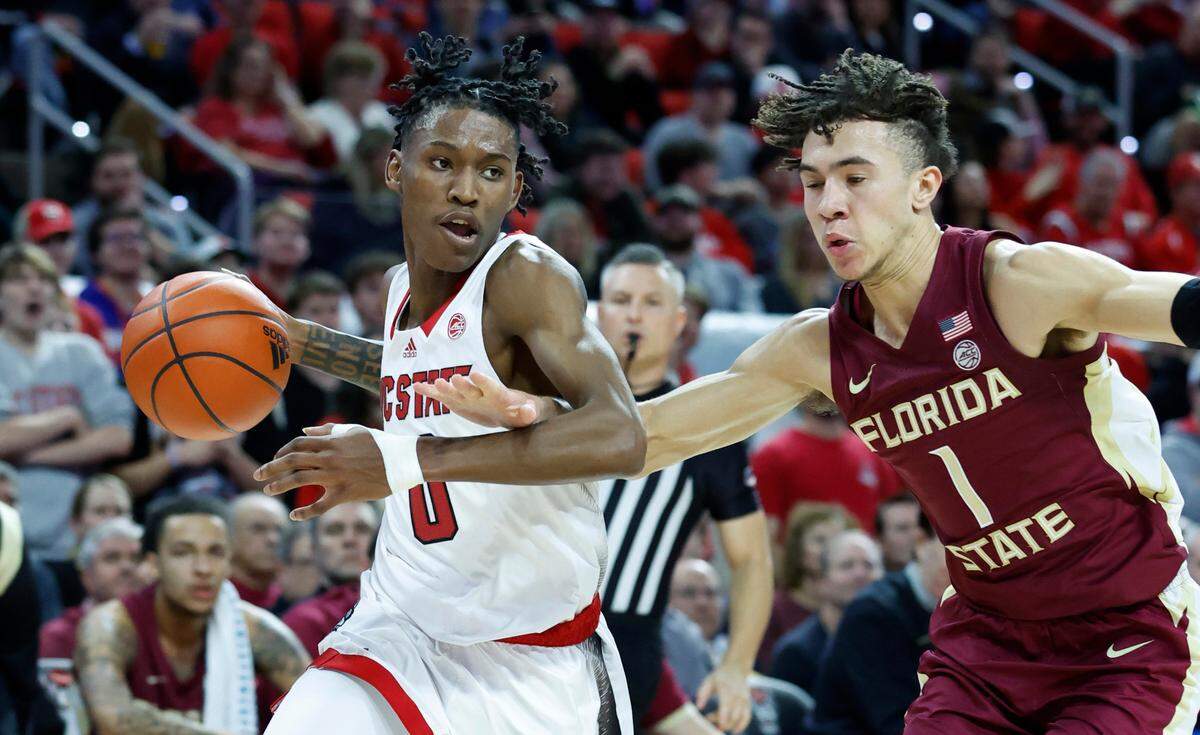 N.C. State’s Terquavion Smith (0) drives by Florida State’s Jalen Warley (1) during the first half of N.C. State’s game against FSU at PNC Arena in Raleigh, N.C., Wednesday, Feb. 1, 2023.