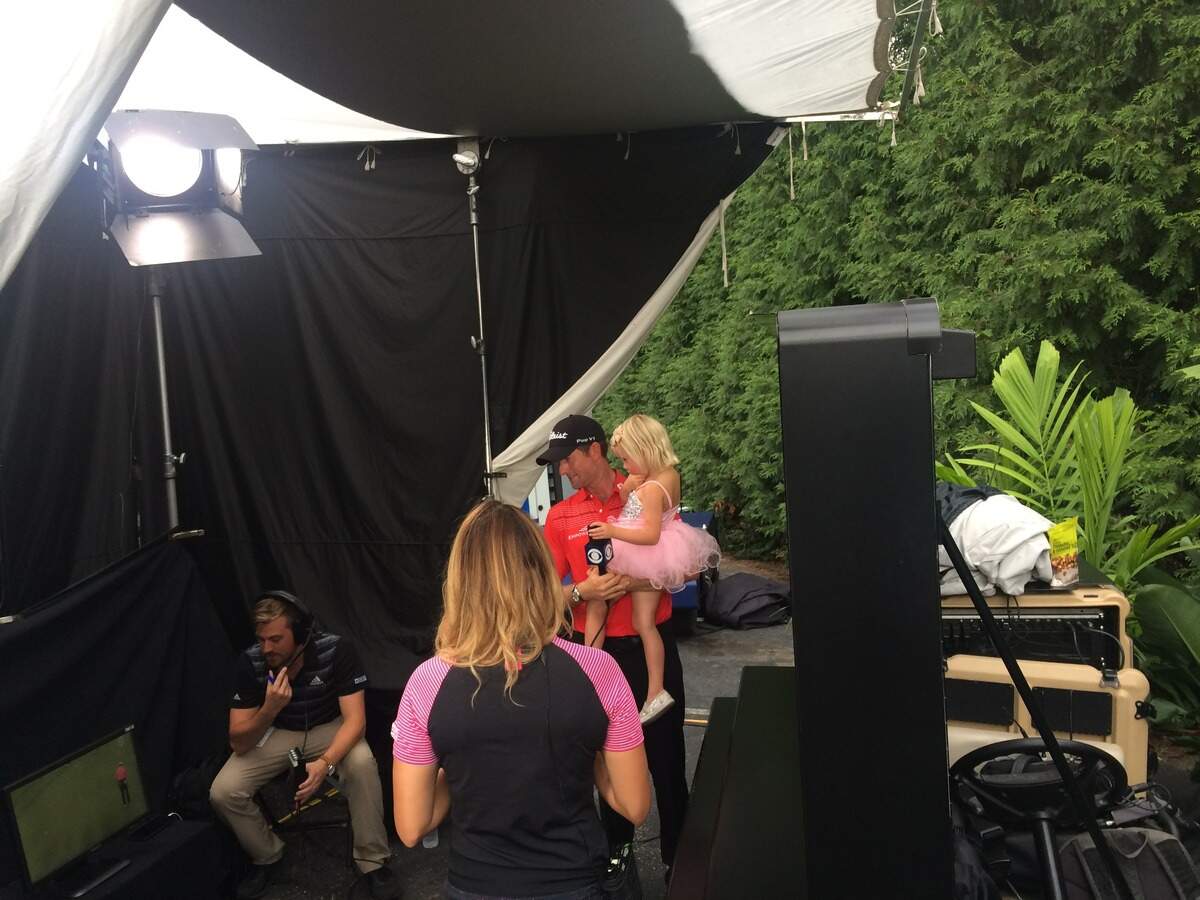 Webb Simpson holds daughter Wyndham, 4, as he discusses his final round at the Wyndham Championship with CBS’ Amanda Balionis on Sunday.