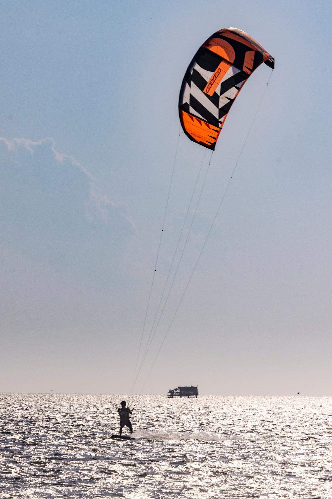 A parasailer cuts a path through calm waters at the Outer Banks. Attention has been focused on homes falling into the ocean as a result of erosion in Buxton and Rodanthe, but the vast majority of the Outer Banks is open for business. 