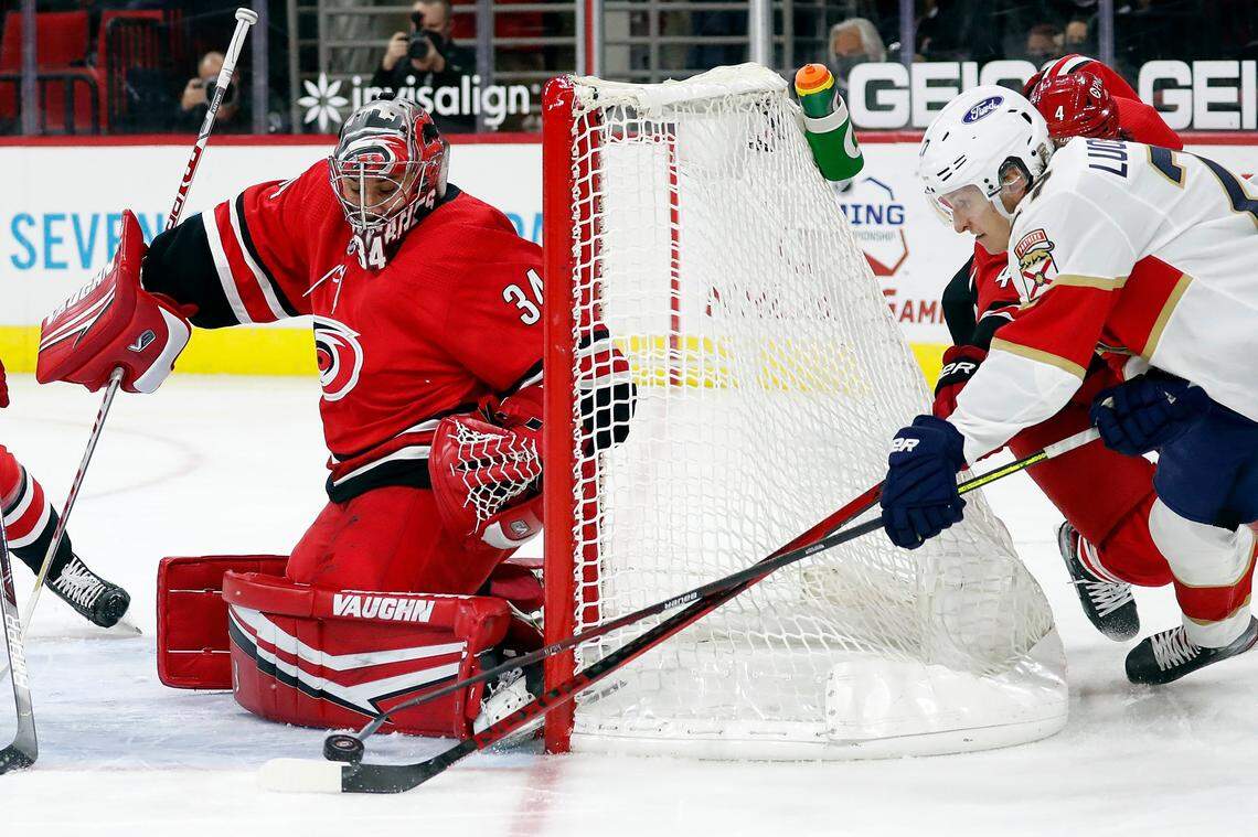 Florida Panthers’ Eetu Luostarinen (27) tries to wrap the puck around the net to shoot at Carolina Hurricanes goaltender Petr Mrazek (34) during the first period of an NHL hockey game in Raleigh, N.C., Tuesday, April 6, 2021. (AP Photo/Karl B DeBlaker)