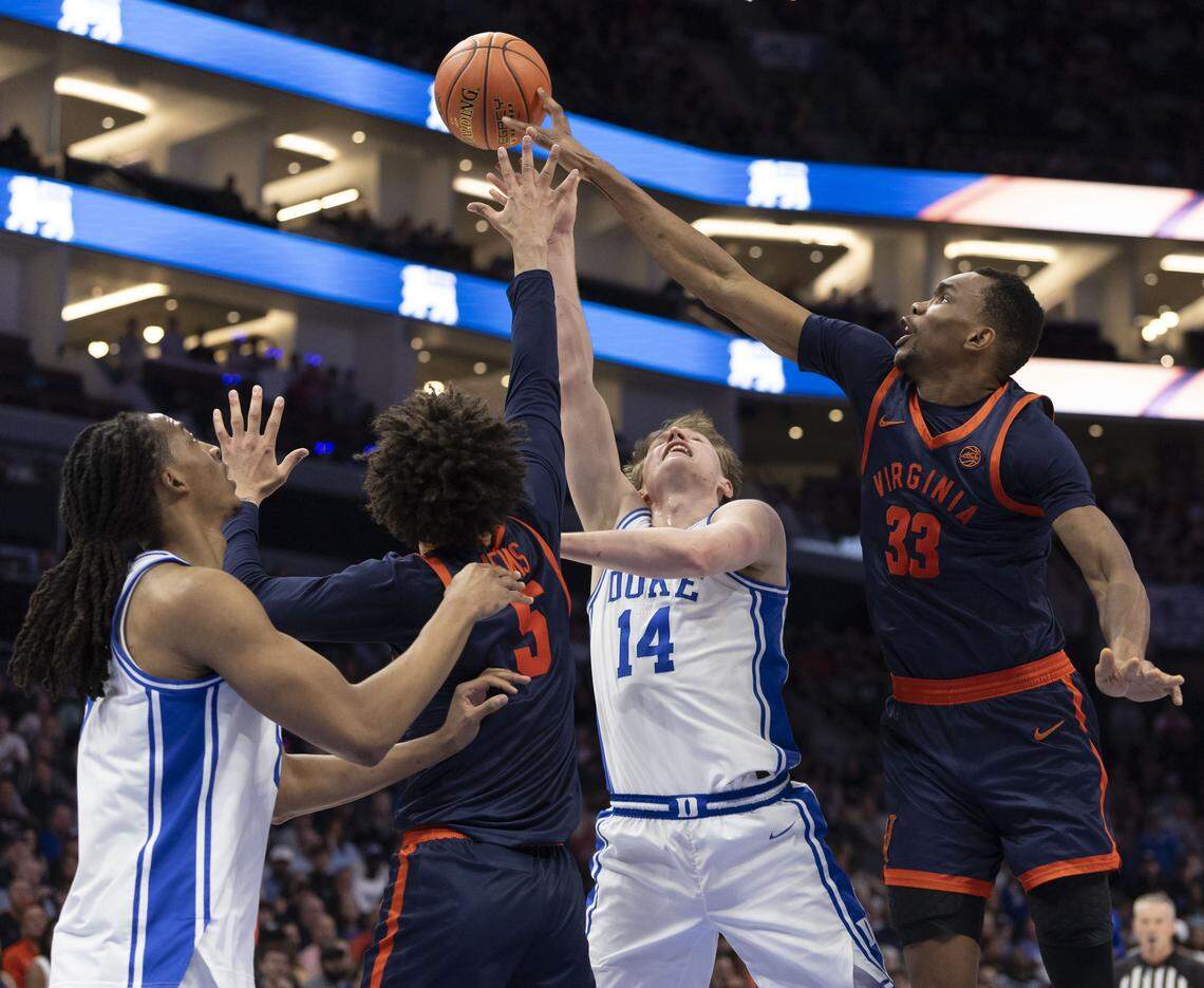 Virginia center Ugonna Onyenso (33) blocks a shot by Duke guard Nikolas Khamenia (14) in the first half on Saturday, March 14, 2026, during the ACC Tournament Championship at Spectrum Center in Charlotte, N.C.