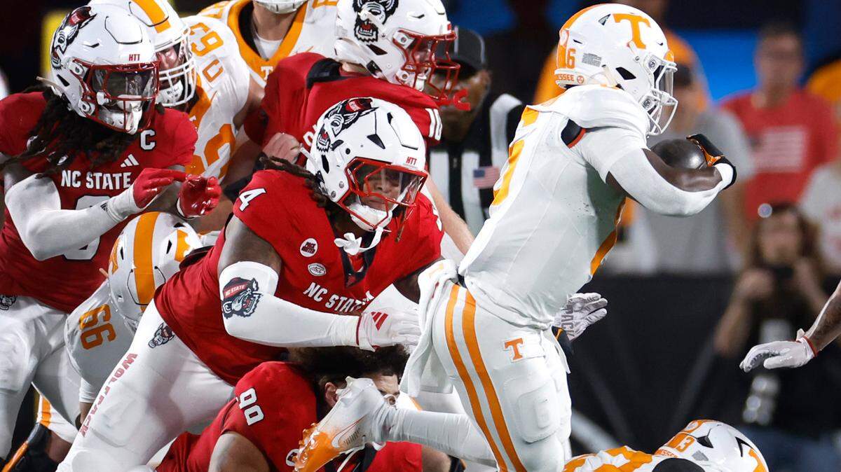 N.C. State defensive end Red Hibbler (4) dives after Tennessee’s Dylan Sampson (6) during the Wolfpack’s game against Tennessee in the Duke’s Mayo Classic at Bank of America Stadium in Charlotte, N.C., Saturday, Sept. 7, 2024.