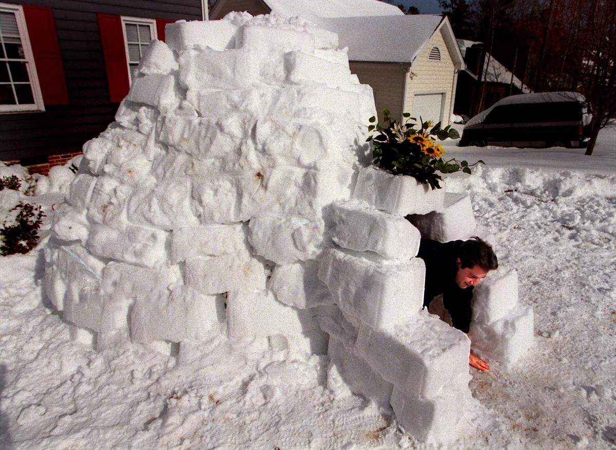 Mike Beaman climbs out of the igloo he built from blocks made by packing snow in the a recycling container in the days following a storm that dumped two feet of snow on the Triangle in one night in 2000.