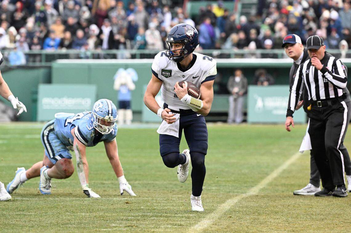 Dec 28, 2024; Boston, MA, USA; Connecticut Huskies quarterback Joe Fagnano (2) runs the ball against the North Carolina Tar Heels  during the first half at Fenway Park. Mandatory Credit: Eric Canha-Imagn Images