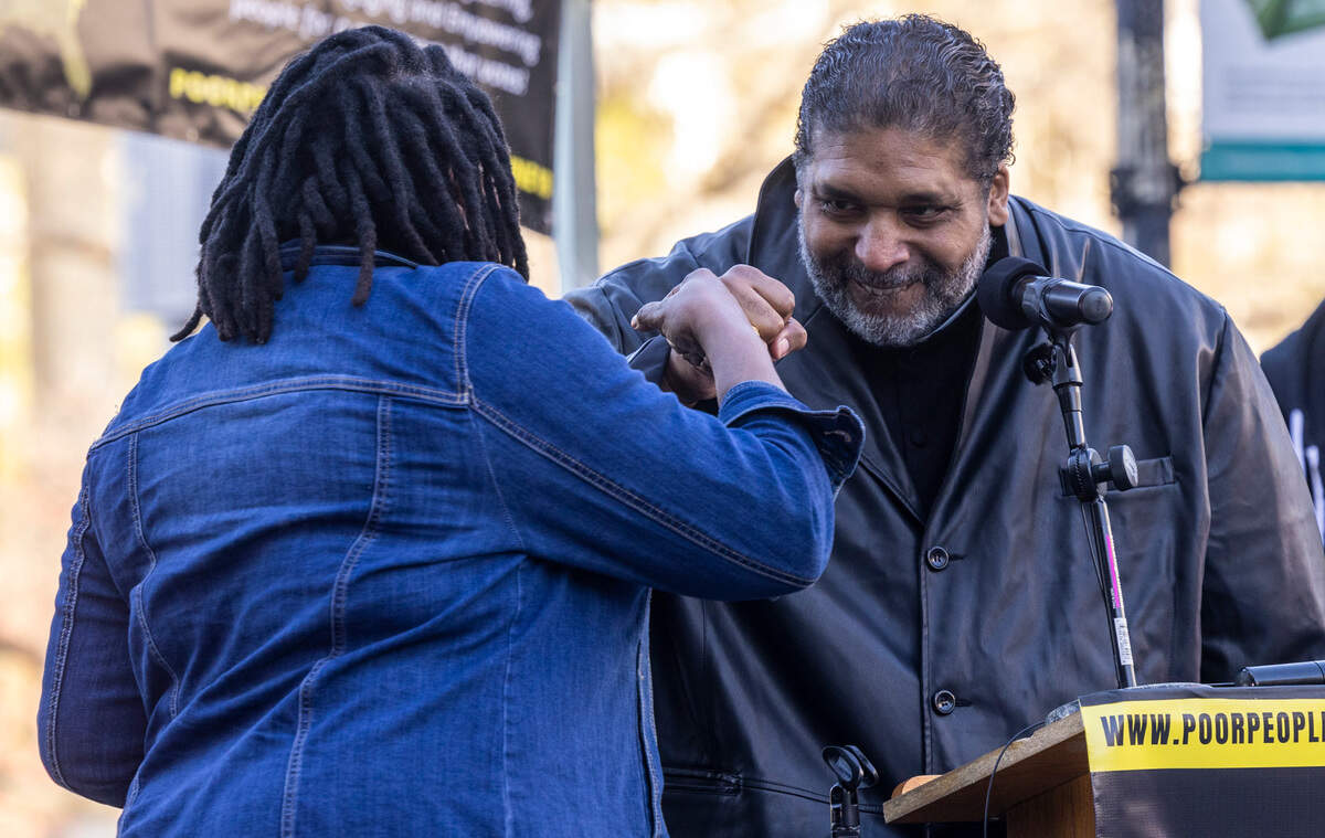 Yara Allen, Director of Cultural Arts & Theomusicologist for Repairers of the Breach, and Rev. William Barber II bump fists during a rally organized by the North Carolina Poor People’s Campaign Monday, March 28, 2022 at the Bicentennial Plaza in Raleigh. The rally was one of a series of assemblies that will culminate in a “Mass Poor People’s and Low-Wage Workers’ Assembly and Moral March on Washington and to the Polls” in Washington D.C. on Jone 18.