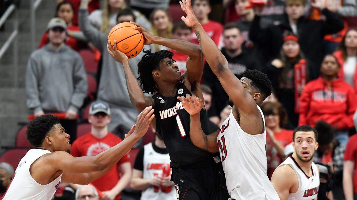 NC State’s Dereon Seabron attempts a shot over Louisville forward Sydney Curry (21) during the second half of an NCAA college basketball game in Louisville, Ky., Wednesday, Jan. 12, 2022. NC State won 79-63. (AP Photo/Timothy D. Easley)