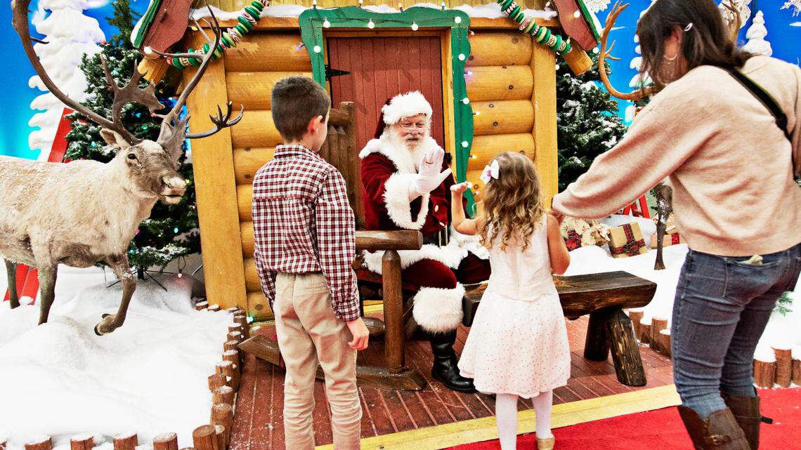 Leo Sabatino, 9, and his five-year-old sister, Elle, give Santa high fives during a visit in Santa’s Wonderland at Bass Pro Shop in Cary on Thursday evening, Nov. 11, 2021. Duane Reaugh has professionally worked as Santa for seven years.