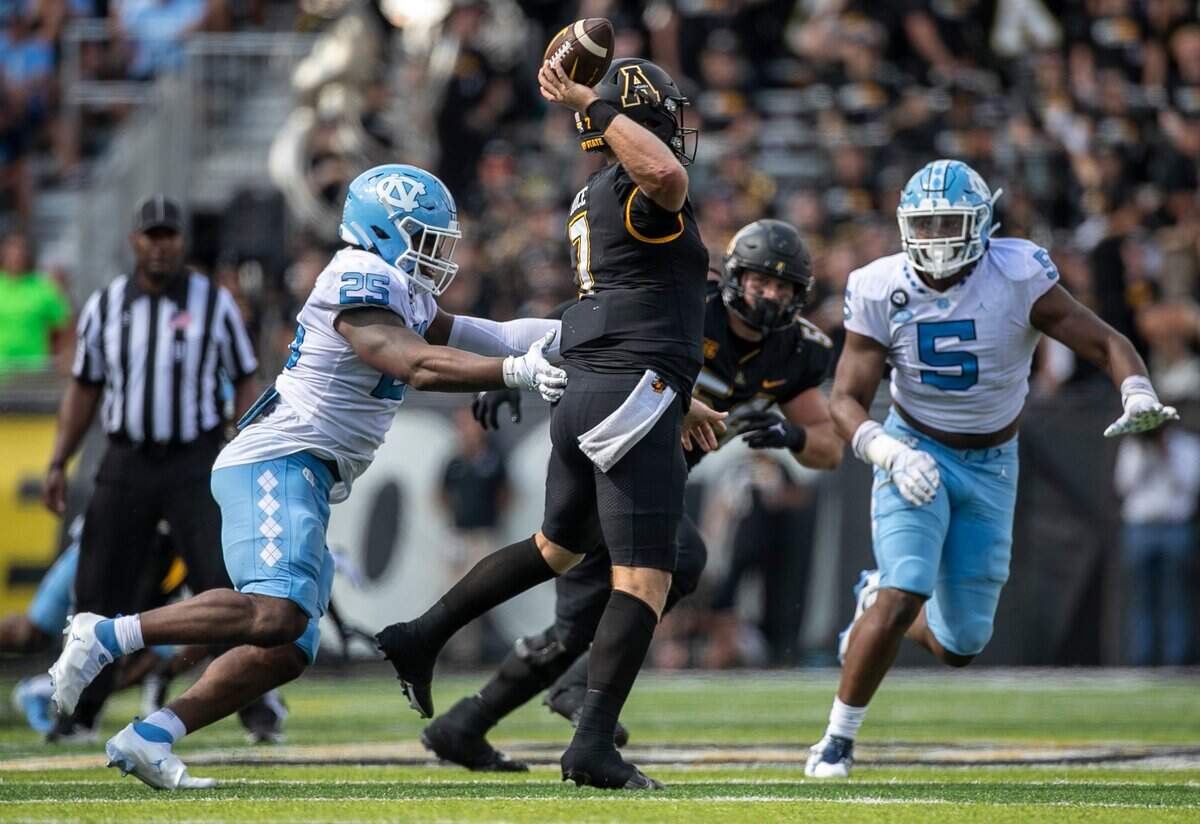 North Carolina’s Caiman Rucker (25) pressures Appalachian State quarterback Chase Brice (7) in the fourth quarter on Saturday, September 3, 2022 at Kidd Brewer Stadium in Boone, N.C.