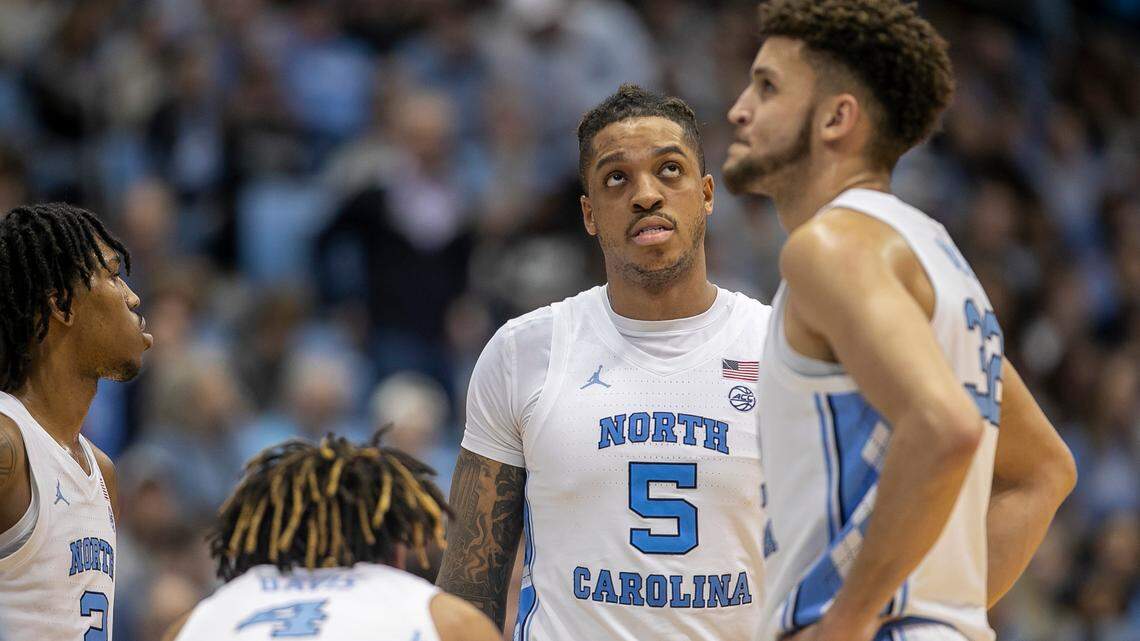Down by ten points to Miami in the second half, North Carolina’s Armando Bacot (5) and Pete Nance (32) glance at the scoreboards as they huddle with teammates Caleb Love (2) and R.J. Davis (4) during a time out on Monday, February 13, 2023 at the Smith Center in Chapel Hill, N.C.