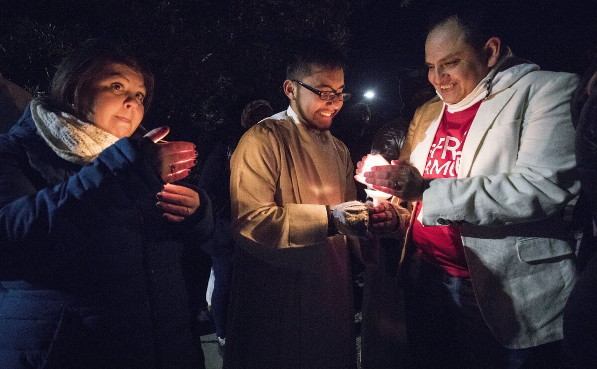Corey Arie Summers, left, Daniel Oliver-Perez, center, and Ernesto Enrique Barriguete, right, warm their hands over candles at the vigil for Daniel’s father, Samuel Oliver-Bruno, on Tuesday, Nov. 27, 2018. Samuel was arrested bye ICE agents in Morrisville on Nov. 23 after leaving CityWell United Methodist Church in Durham where he was in sanctuary to attend an appointment at USCIS.