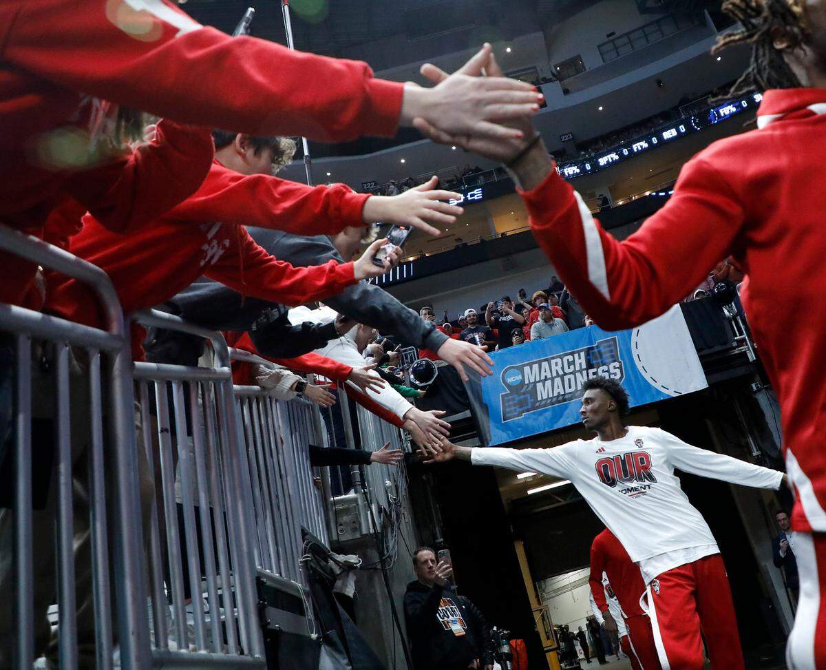 N.C. State’s Ernest Ross high-fives fans as the Wolfpack take the court prior to their NCAA Tournament second round game against Oakland on Saturday, March 23, 2024, at PPG Paints Arena in Pittsburgh, Pa.