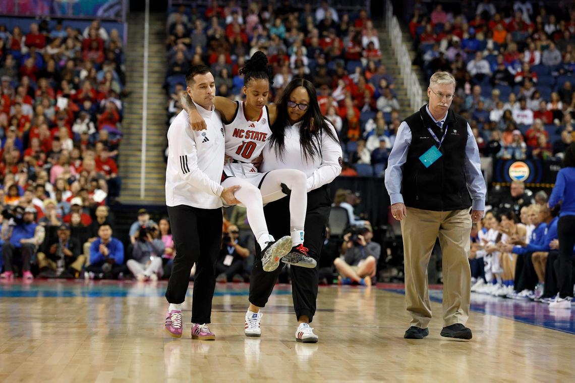 N.C. State’s Aziaha James is helped off the court after an apparent injury during the first half of the ACC Tournament final against Duke on Sunday, March 9, 2025, at First Horizon Coliseum in Greensboro, N.C.