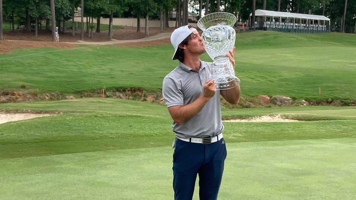 Mito Pereira of Chile gives Rex Hospital Open trophy a kiss after winning Sunday on the first hole of a playoff against Stephan Jaeger on the Korn Ferry Tour.