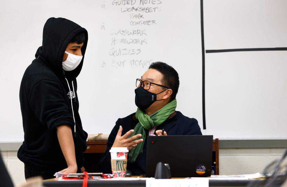 Paul Koh, assistant superintendent of student support services for the Wake County School System, talks with tenth-grader Gonzalo Gomez-Escobar while substitute teaching the Principles of Business and Finance class at Sanderson High School in Raleigh, N.C., Friday, Nov. 5, 2021. The school system is having central office administrators work at schools one day a week to help with staffing shortages.