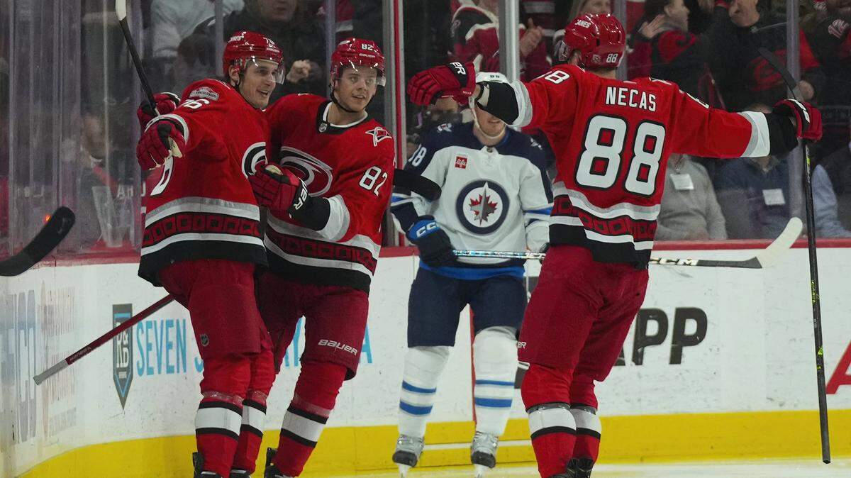 Carolina Hurricanes defenseman Brady Skjei (76) celebrates his goal with center Martin Necas (88) and center Jesperi Kotkaniemi (82) against the Winnipeg Jets during the second period at PNC Arena.