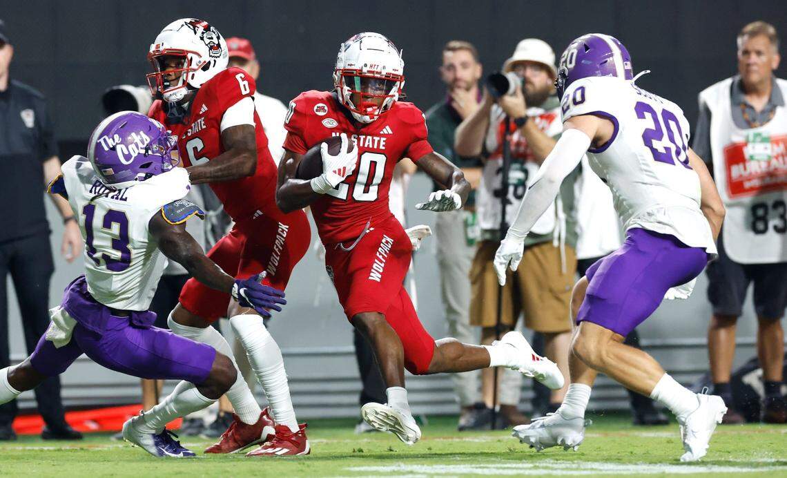 N.C. State running back Hollywood Smothers (20) gains yards as Western Carolina linebacker Wesley Scott (20) closes in during the first half of N.C. State’s game against Western Carolina at Carter-Finley Stadium in Raleigh, N.C., Thursday, August 29, 2024.