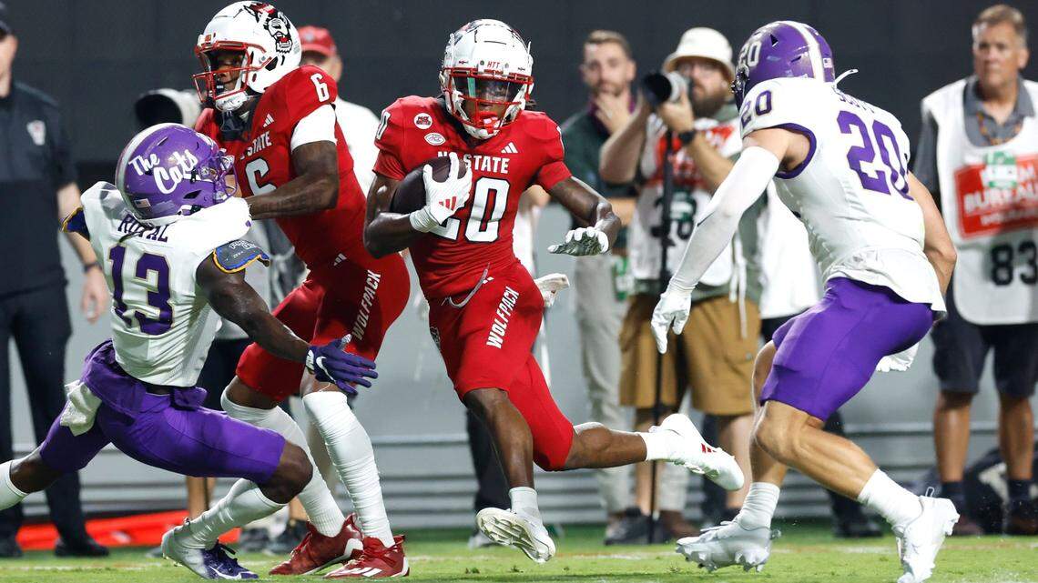 N.C. State running back Hollywood Smothers (20) gains yards as Western Carolina linebacker Wesley Scott (20) closes in during the first half of N.C. State’s game against Western Carolina at Carter-Finley Stadium in Raleigh, N.C., Thursday, August 29, 2024.