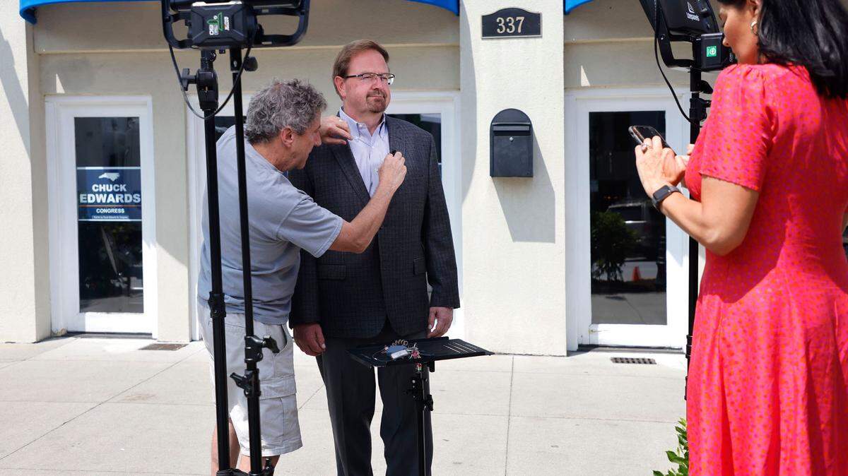 Alan Meshberg adjusts the microphone before State Sen. Chuck Edwards is interviewed by CNN’s Dianne Gallagher outside Edwards’ office in Hendersonville, N.C., Wednesday, May 18, 2022.