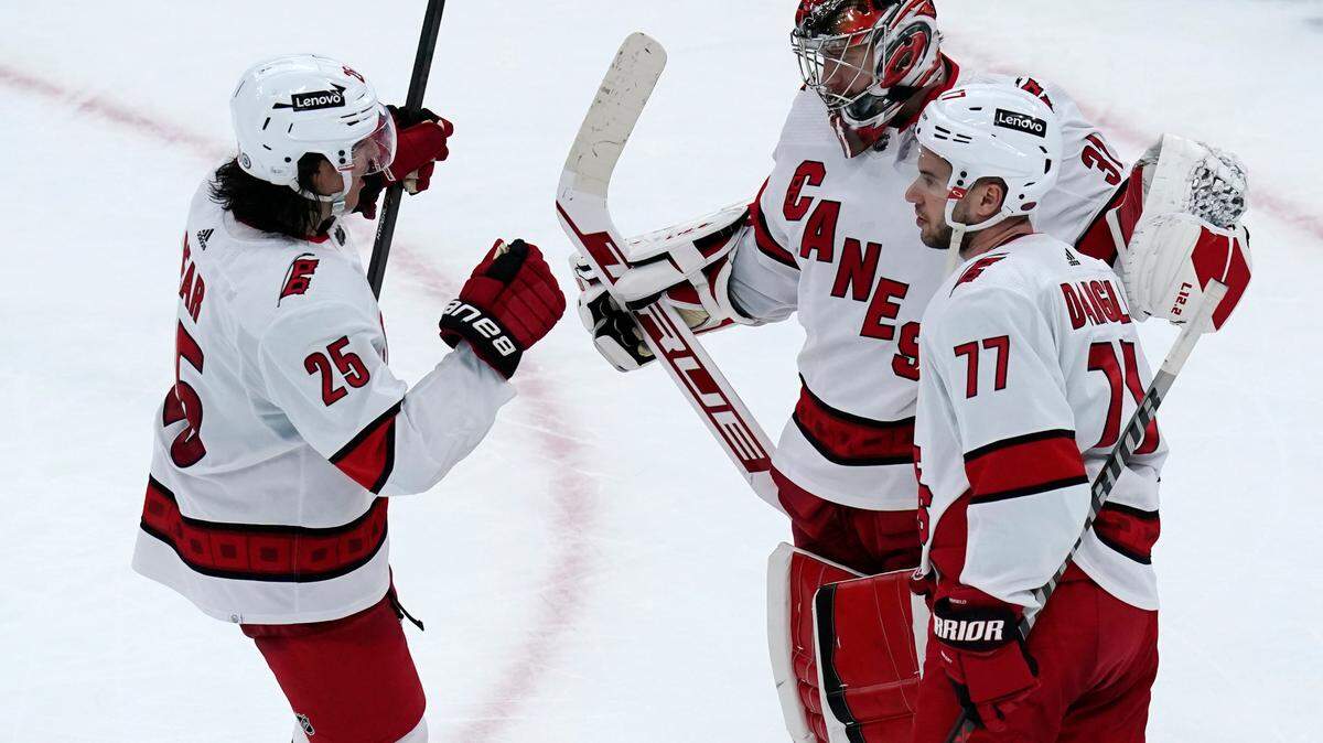 Carolina Hurricanes goaltender Frederik Andersen is congratulated by Ethan Bear (25) and Tony DeAngelo (77) after shutting out the Boston Bruins 6-0 in an NHL hockey game, Thursday, Feb. 10, 2022. (AP Photo/Charles Krupa)
