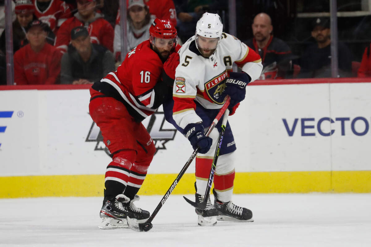 Carolina Hurricanes’ Vincent Trocheck (16) battles with Florida Panthers’ Aaron Ekblad (5) for the puck during the third period of an NHL hockey game in Raleigh, N.C., Saturday, Jan. 8, 2022. (AP Photo/Karl B DeBlaker)