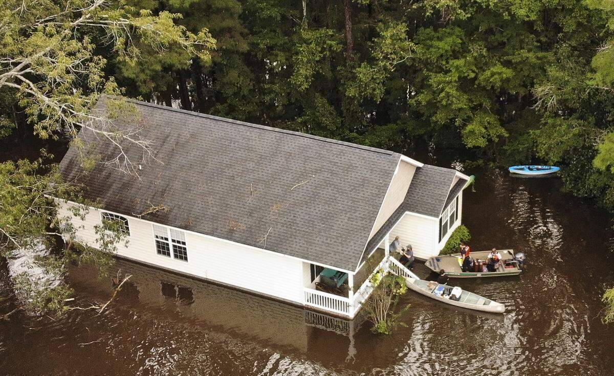 An elderly woman is rescued from a home in Conway, South Carolina on Monday morning. A neighborhood along the Crabtree Swamp, near the Waccama River flooded overnight. 