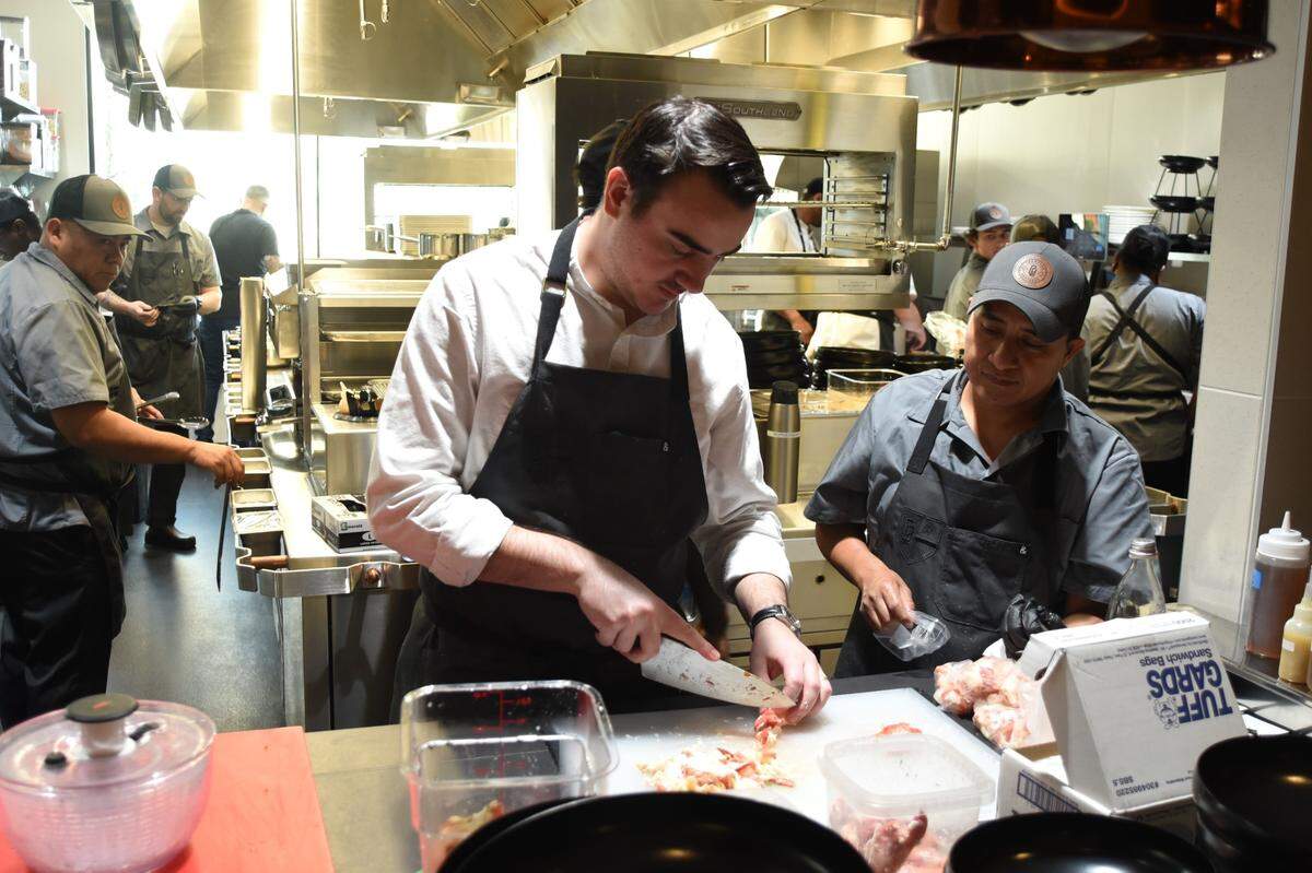 During the opening week of Crawford Brothers Steakhouse, culinary director Conor Delaney chops lobster in the kitchen.