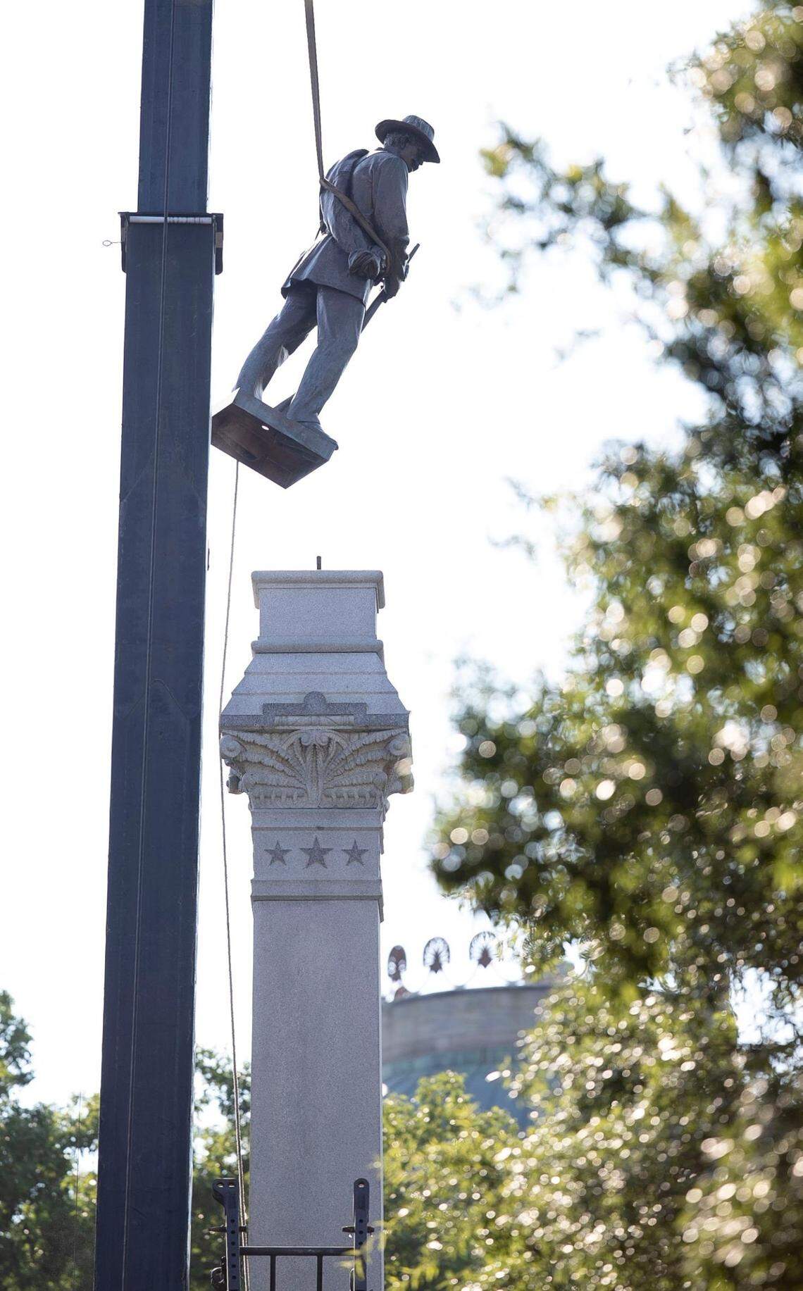 The Confederate soldier statue atop the historic Confederate monument on the west side of the North Carolina State Capital grounds is removed by a crane on Sunday, June 21, 2020 in Raleigh, N.C.