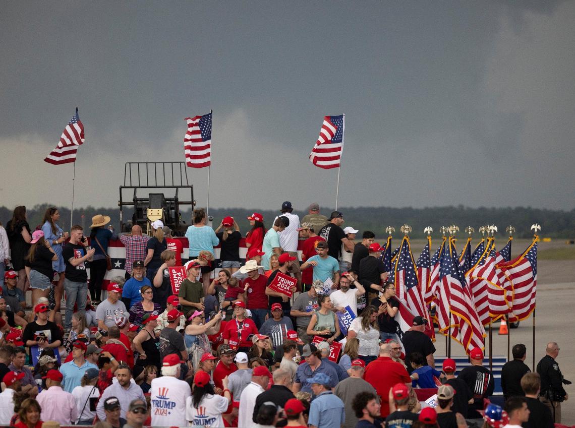 With storm clouds on the horizon, supporters of former President Donald Trump await his arrival at the Aero Center at the Wilmington Airport on Saturday, April 20, 2024 in Wilmington, N.C. Moments later the rally was canceled due to the threat of severe weather.