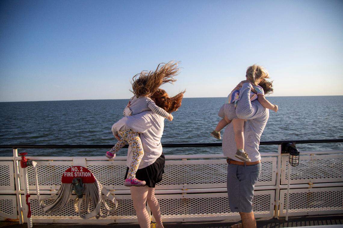A stiff breeze blows across the top deck of a ferry as Lauren and Nate James ride with their daughters Eden, 4, and Polly, 2, across the Pamlico Sound from Swan Quarter to Ocracoke Tuesday, May 17, 2022.