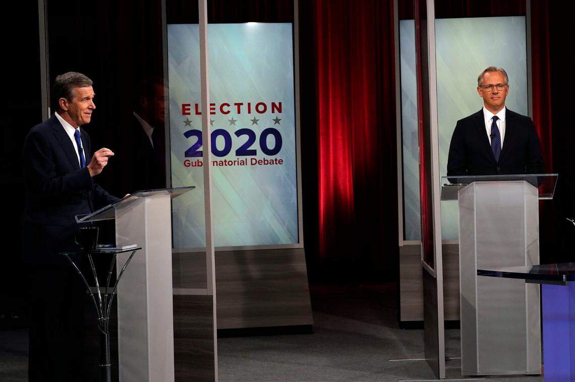 North Carolina Gov. Roy Cooper, left, and Lt. Gov. Dan Forest participate in a live televised debate at UNC-TV studios in Research Triangle Park, N.C., Wednesday, Oct. 14, 2020.