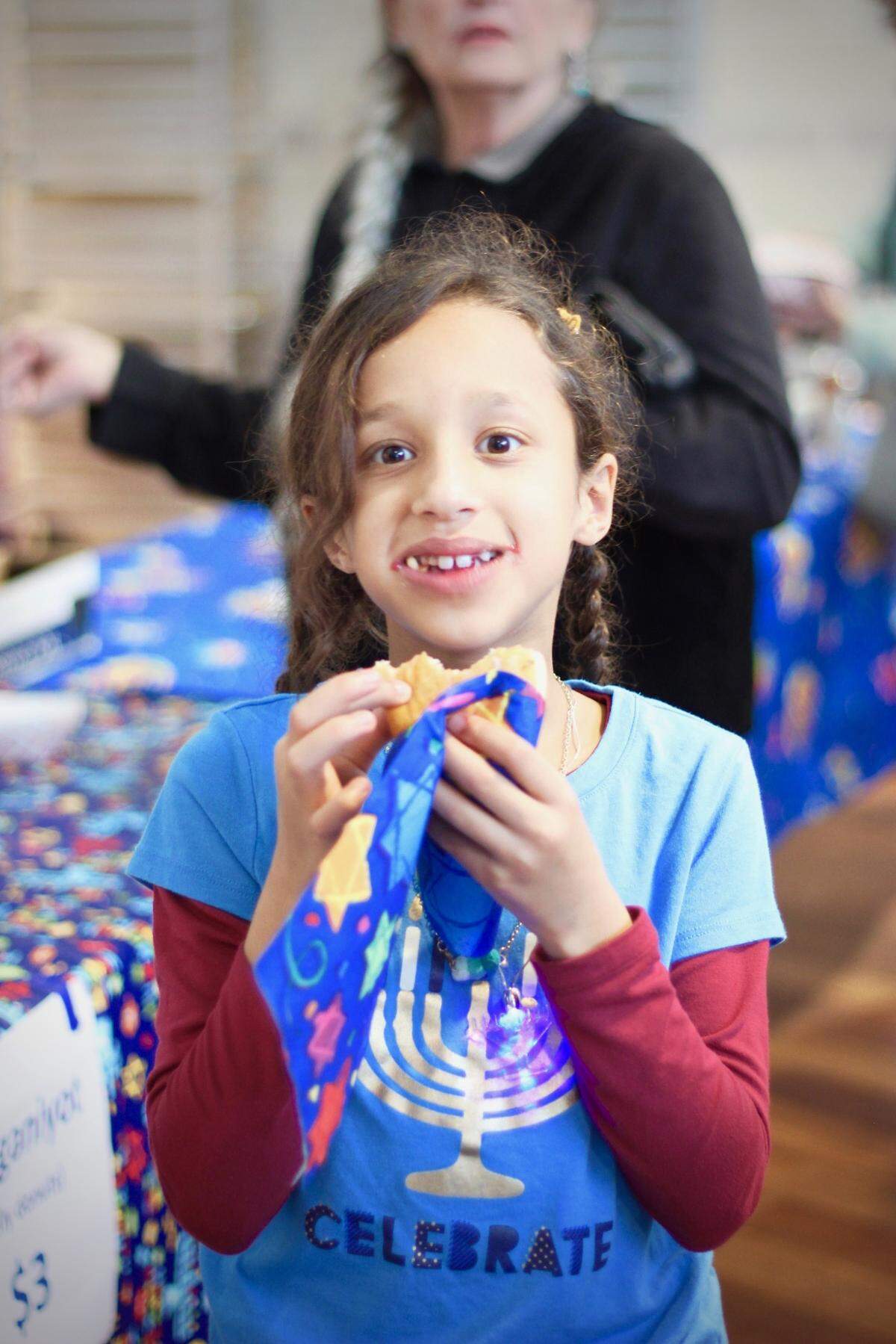 One of Jewish for Good’s 2019 Hanukkah Festival attendees digs into her sufganyot, or jelly doughnuts
