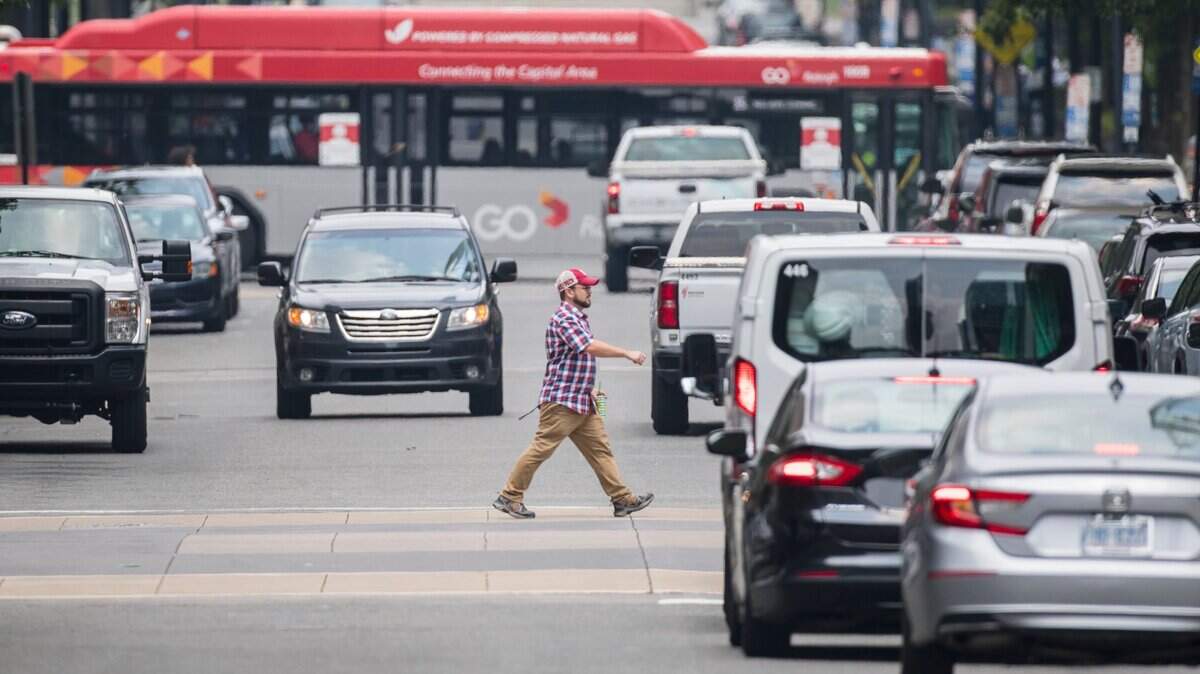 A man crosses Fayetteville Street in downtown Raleigh, N.C. during lunch hours on Thursday, July 22, 2021.