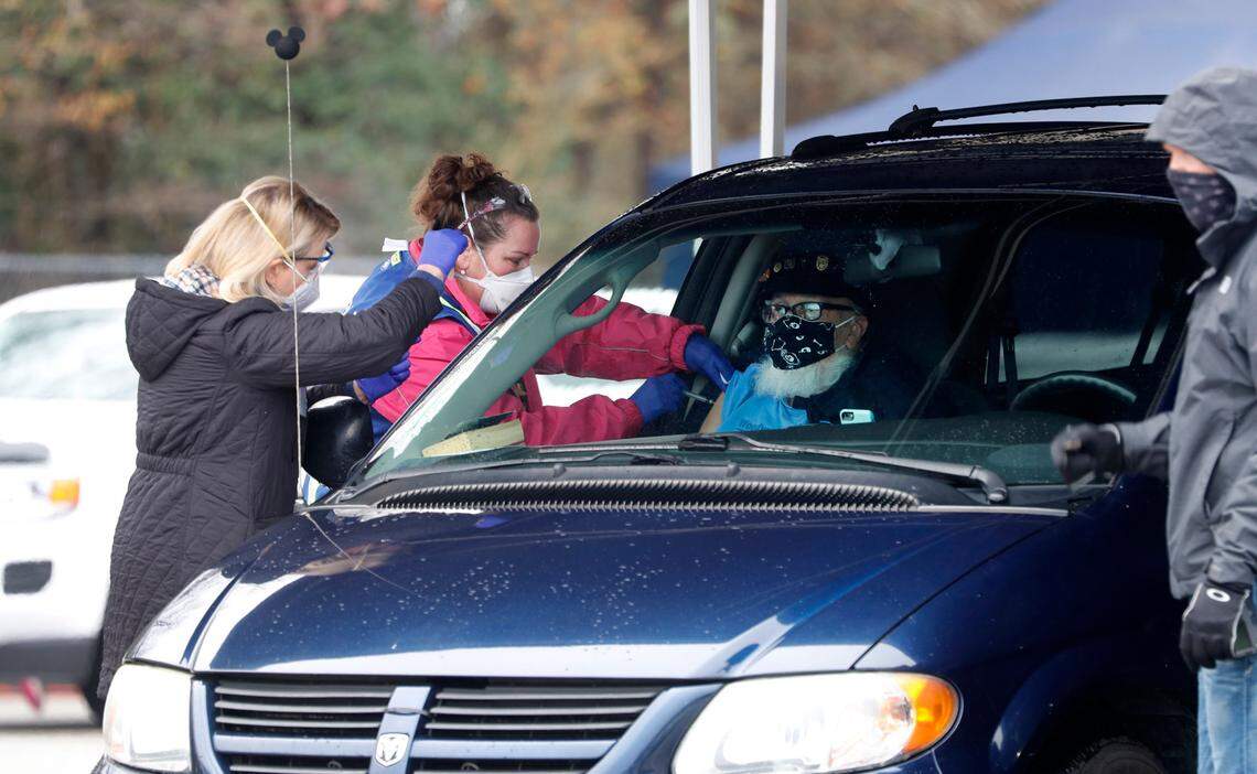 David Story, 79, of Garner, gets his vaccine shot during a drive-thru COVID vaccination clinic at West Johnston High School in Benson, N.C., Tuesday, January 12, 2021. The Johnston County Health Department clinic was for anyone 75 and older and was offered first come, first served for the first 500 who arrived.